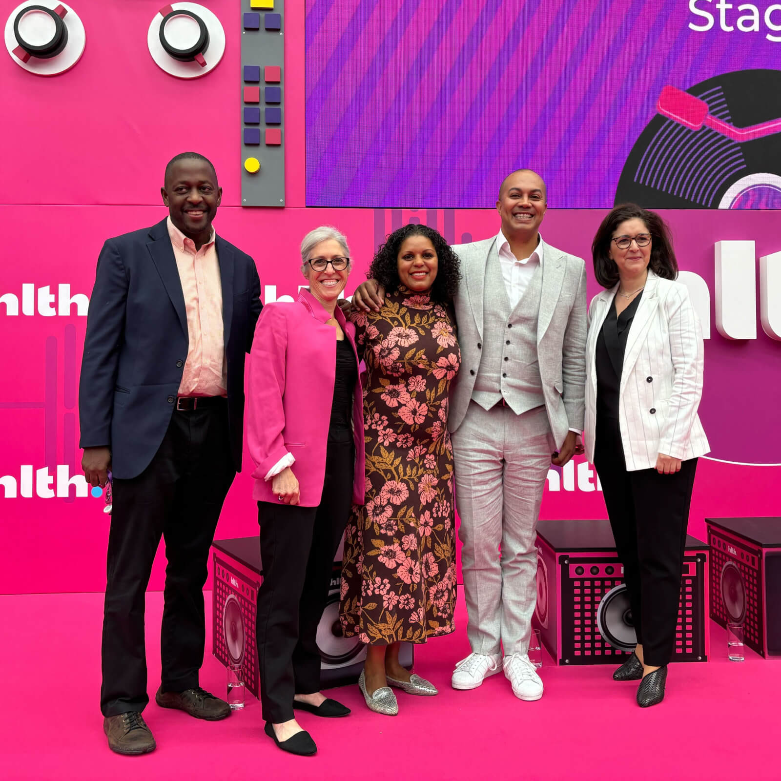 Five people in front of HLTH Europe conference banners