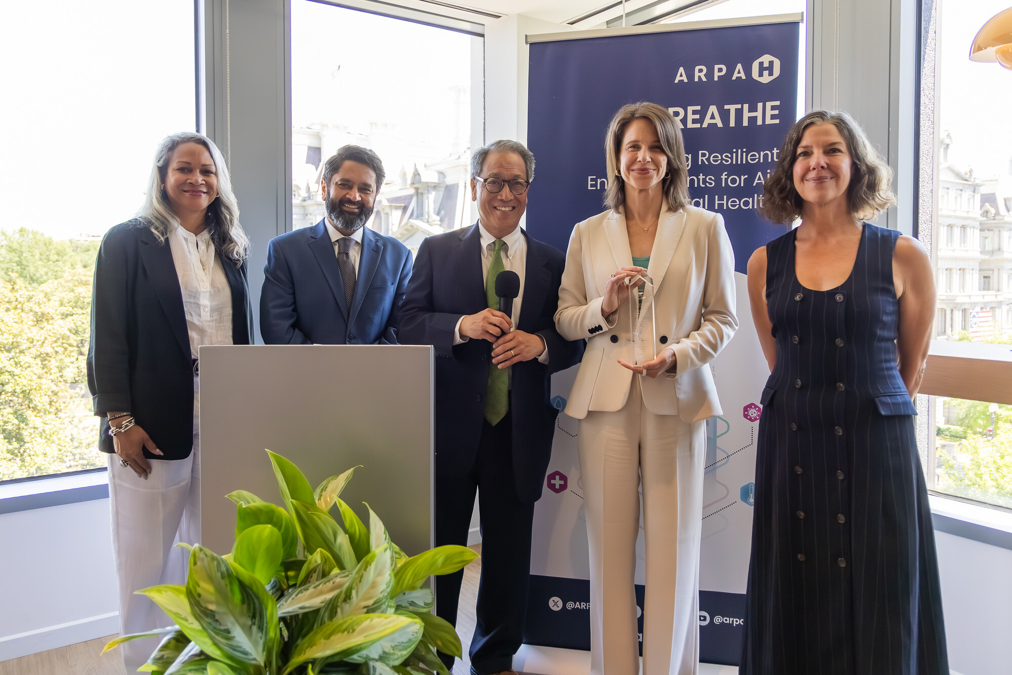 Two ARPA-H staff accept an award from three other people.
